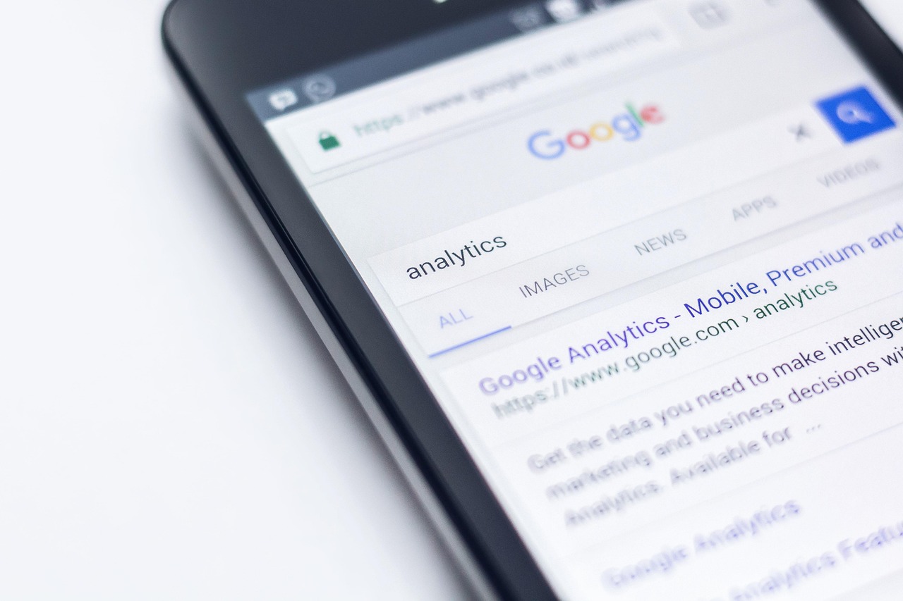 Telefon z widocznymi wynikami wyszukiwania Google na ekranie przeglądarki.